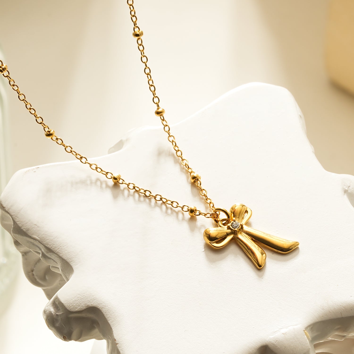 TALIANA Gold : Collier délicat à perles avec pendentif nœud et zircone solitaire – Bijou élégant pour tous les jours