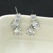 THEOLA : Boucles d'oreilles créoles en forme de pile de trois moissanites, effet éclatant, en or blanc argenté.
