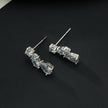 THEOLA : Boucles d'oreilles créoles en forme de pile de trois moissanites, effet éclatant, en or blanc argenté.