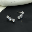 THEOLA : Boucles d'oreilles créoles en forme de pile de trois moissanites, effet éclatant, en or blanc argenté.
