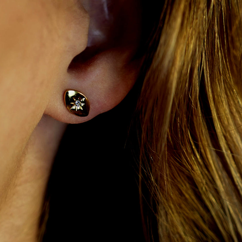 TINDRA : Boucles d'oreilles en forme d'ovale en or avec un zircon solitaire.