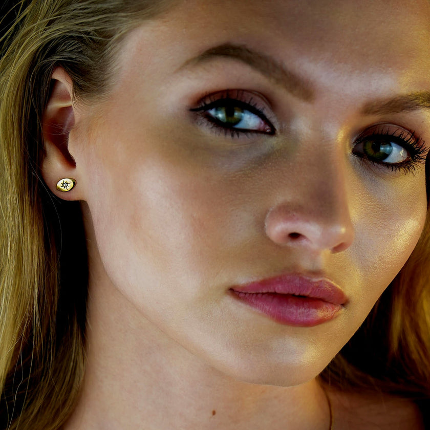 TINDRA : Boucles d'oreilles en forme d'ovale en or avec un zircon solitaire.