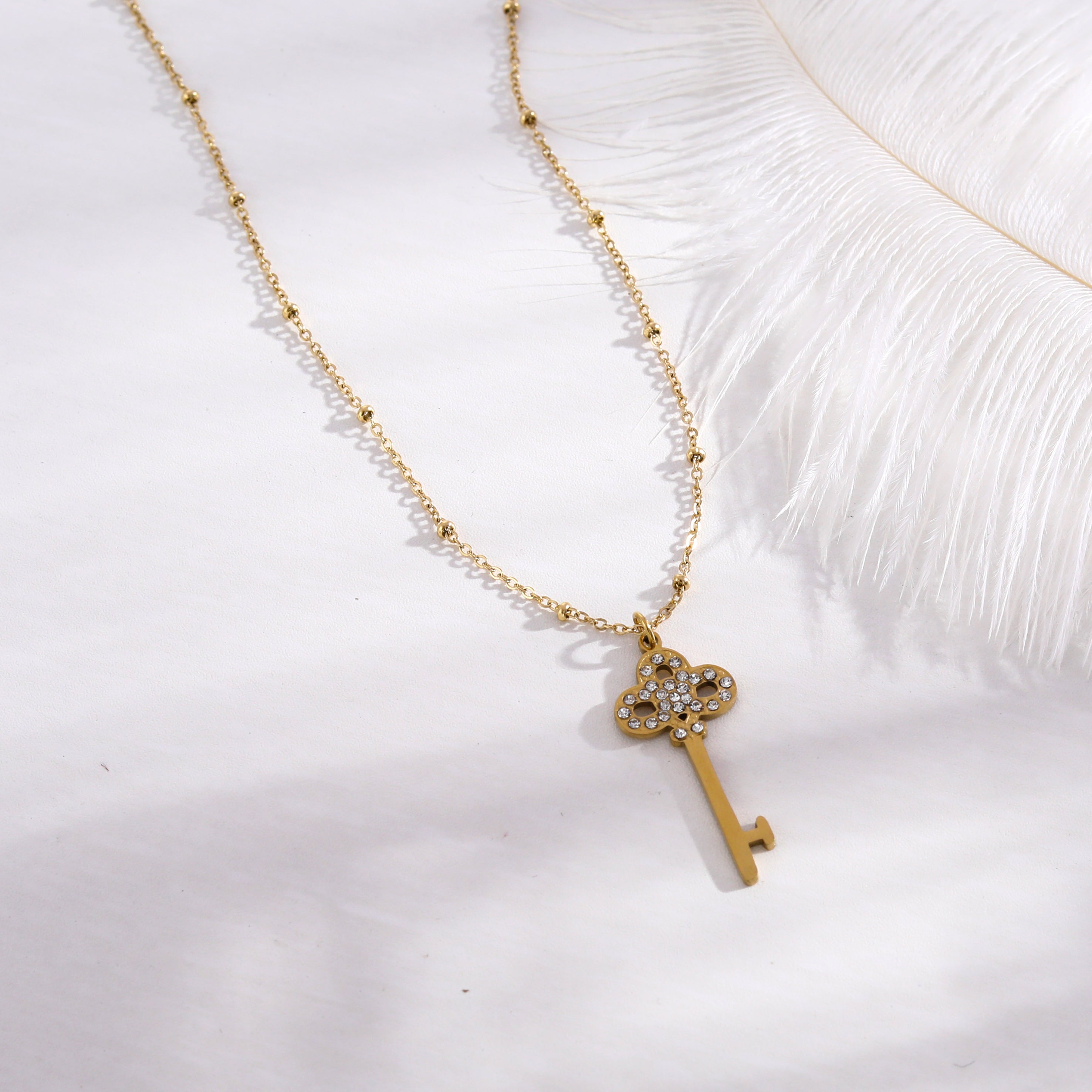 Collier UNLOK en or perlé avec pendentif clé orné de zircons.