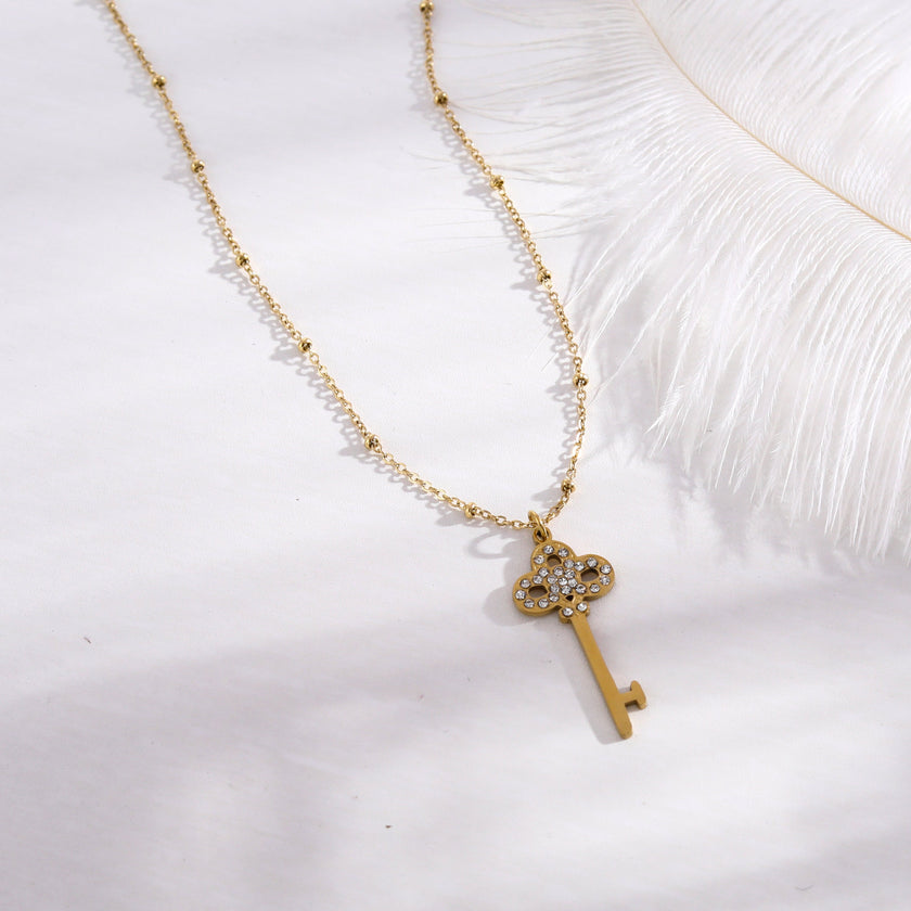 Collier UNLOK en or perlé avec pendentif clé orné de zircons.