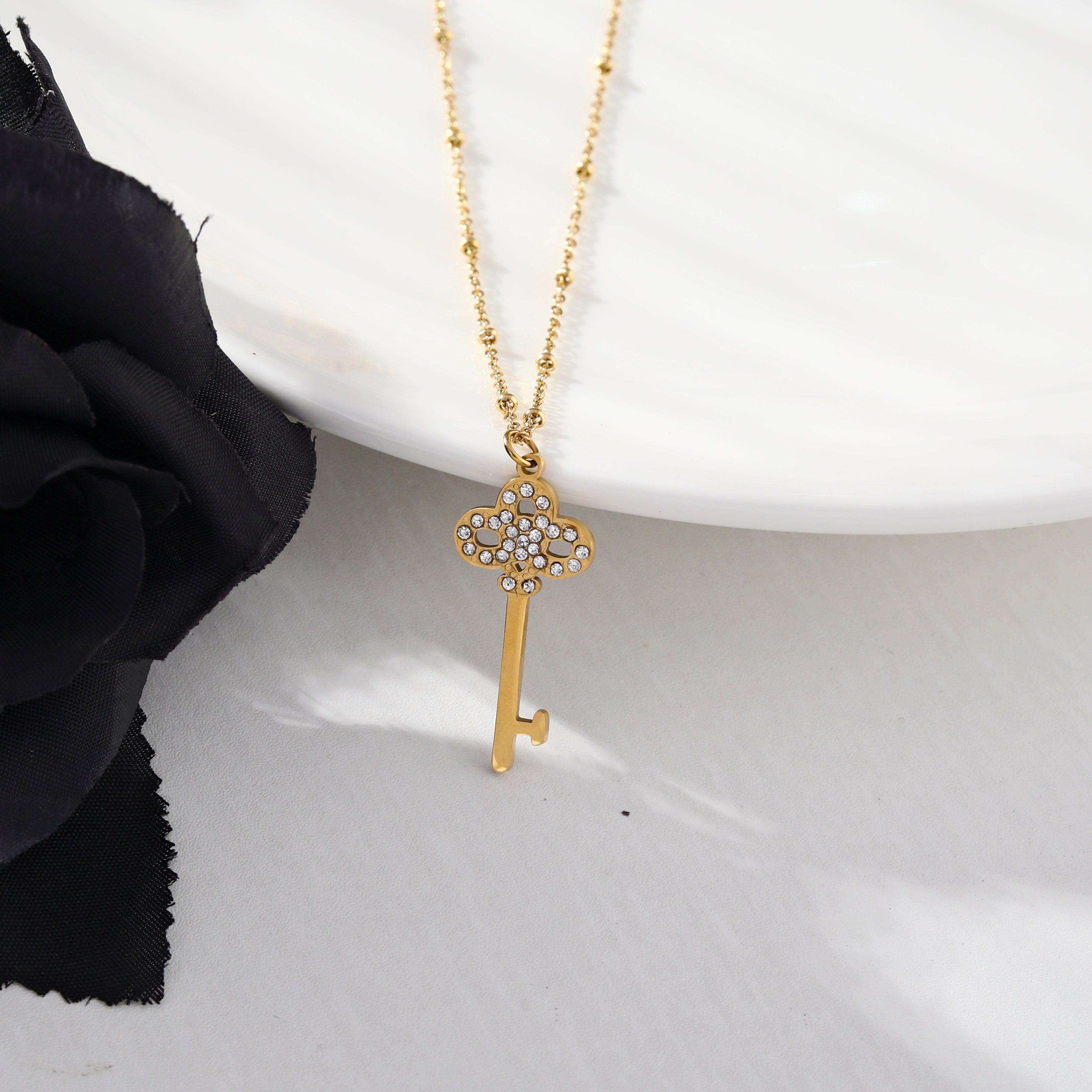 Collier UNLOK en or perlé avec pendentif clé orné de zircons.