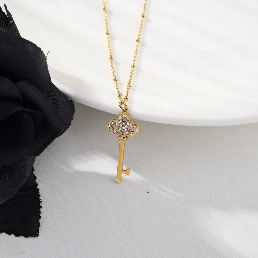Collier UNLOK en or perlé avec pendentif clé orné de zircons.