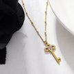 Collier UNLOK en or perlé avec pendentif clé orné de zircons.