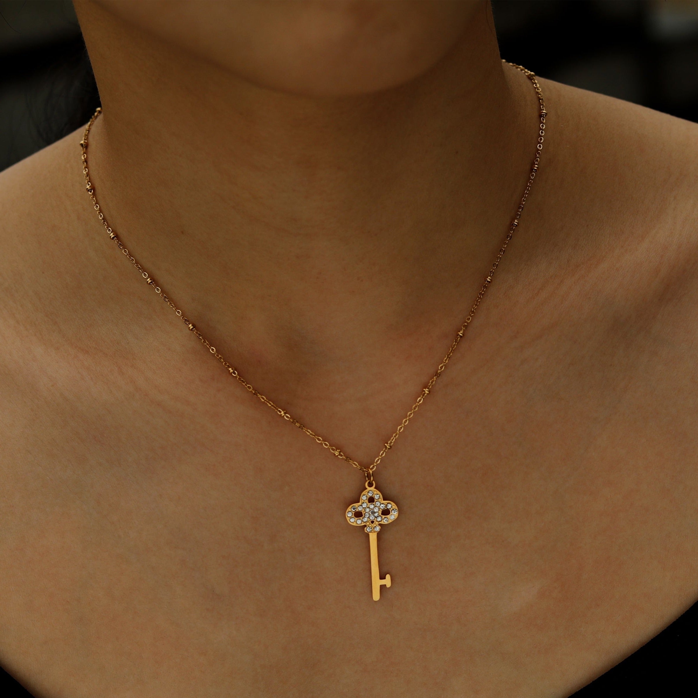 Collier UNLOK en or perlé avec pendentif clé orné de zircons.