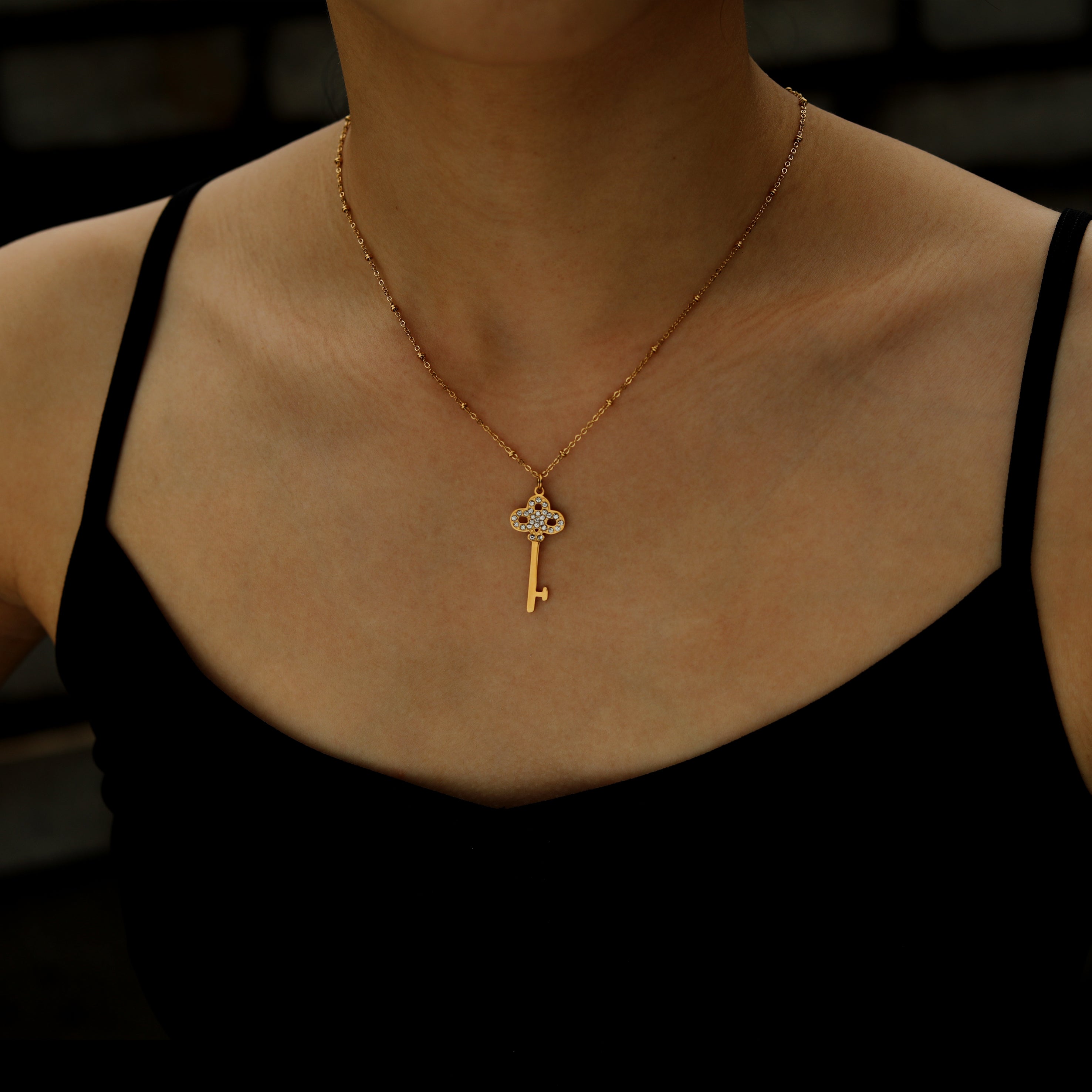 Collier UNLOK en or perlé avec pendentif clé orné de zircons.